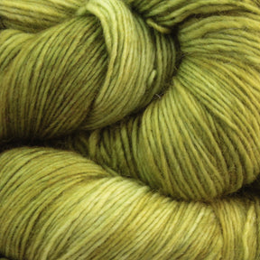 Close-up image of skeins of Malabrigo Lace by Malabrigo Yarn, featuring merino wool yarn in various shades of green, from light to dark. The soft and woolly texture highlights gentle twists and natural variations in the fiber, making it ideal for crafting vibrant, earthy knitted shawls.