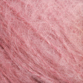 Close-up image of a Victorian Brushed Mohair Yarn | Mini Skein by Caledonian Dye Works, showcasing its soft and fluffy texture with a mix of lighter and darker pink fibers intertwined, reminiscent of luxurious mohair.