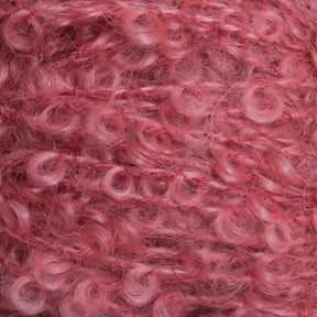 Close-up of textured, curly pink yarn. The yarn has a soft, fluffy appearance with tightly wound loops in a consistent pattern. The fibers reflect light, contributing to its vibrant, rich pink hue—a perfect example of Caledonian Dye Works' Victorian Bouclé Mohair Yarn.