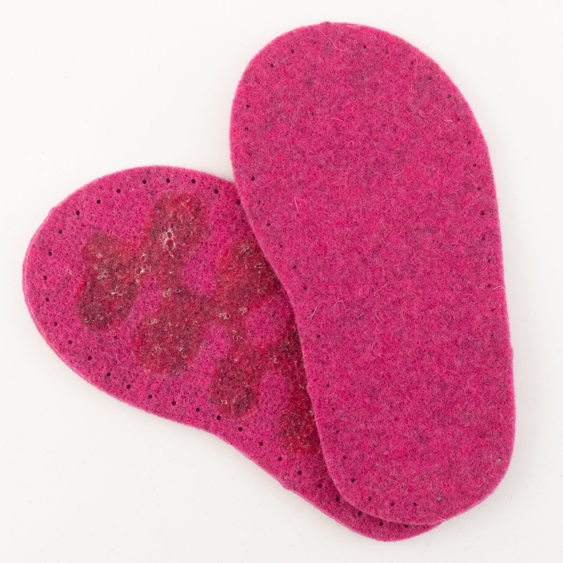 Introducing Joe's Toes Children's Thick Felt Slipper Soles w/Latex Grip in a vibrant pink color. One insole reveals a faint pattern on its top side, while the other exposes the plain, textured underside. The eco-friendly edges feature small perforations for breathability.