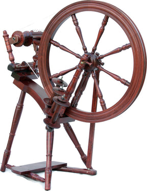 The Kromski Interlude Spinning Wheel by Kromski North America is a vintage wooden spinning wheel made from European alder and birch. It features a single drive angle treadle and a large spoked wheel, with intricate detailing that showcases classic and elegant craftsmanship, making it perfect for spinning yarn or thread.