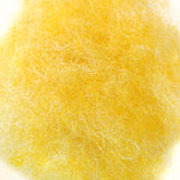 A close-up view of a fluffy, yellow, fibrous material spread out evenly. The texture appears soft and wispy, resembling either fine wool or synthetic fibers. The background is plain and white, providing contrast to the bright yellow material reminiscent of Harrisville Dyed & Carded Wool Fiber from Harrisville Designs.