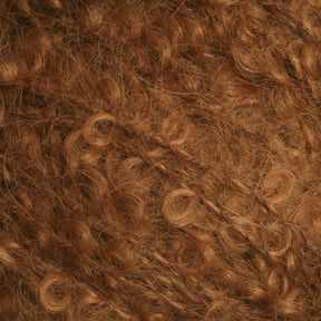 Close-up view of a mass of curly, reddish-brown hair, showcasing its dense, coiled texture and natural shine. The tightly wound curls resemble the luxurious feel of Caledonian Dye Works' Victorian Bouclé Mohair Yarn, varying slightly in size and shape to create a rich, voluminous effect.