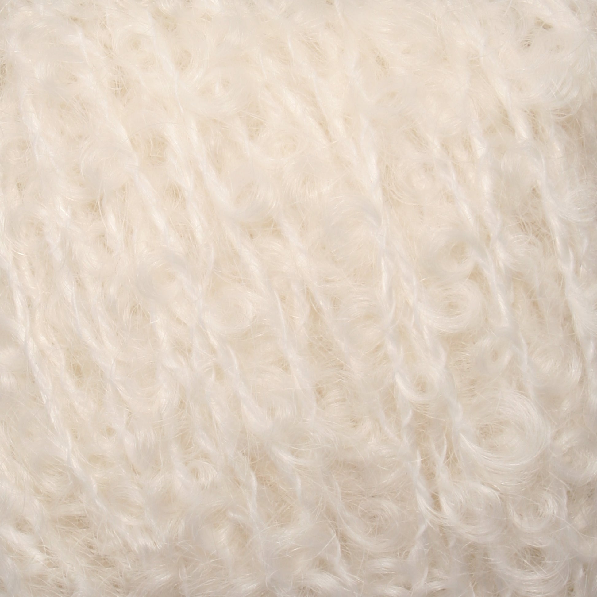 Close-up view of soft, white, textured yarn with a fluffy and lightly curled appearance. The fibers are intertwined, showcasing a delicate and cozy look reminiscent of Caledonian Dye Works' Signature Victorian Bouclé Mohair Yarn, commonly used for knitting or crocheting warm garments and accessories.