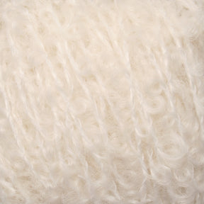 Close-up view of soft, white, textured yarn with a fluffy and lightly curled appearance. The fibers are intertwined, showcasing a delicate and cozy look reminiscent of Caledonian Dye Works' Signature Victorian Bouclé Mohair Yarn, commonly used for knitting or crocheting warm garments and accessories.