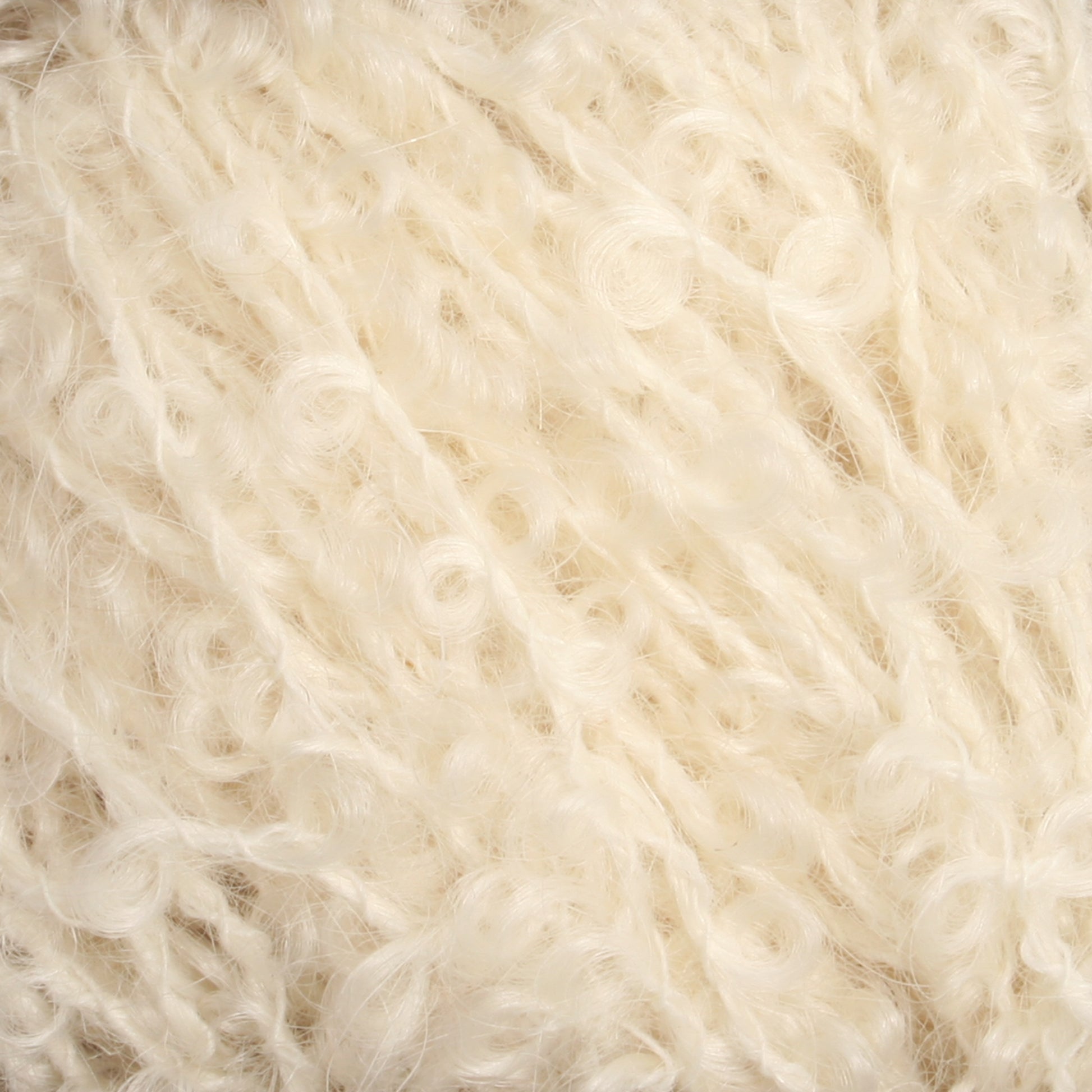 Close-up image of off-white textured yarn strands from Caledonian Dye Works' Victorian Bouclé Mohair Yarn, featuring a mix of curly and straight fibers that create a soft and fluffy appearance.