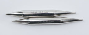 Two metallic knitting needle tips, likely from the Accessories Unlimited Nova Platina Interchangeable Knitting Needles, 4.5" Tip, are aligned vertically against a plain white background. Each tip is engraved with "US 17 / 12.0 mm," indicating the size. The sleek, smooth, and tapered tips resemble hollow brass pipes in their craftsmanship and elegance.