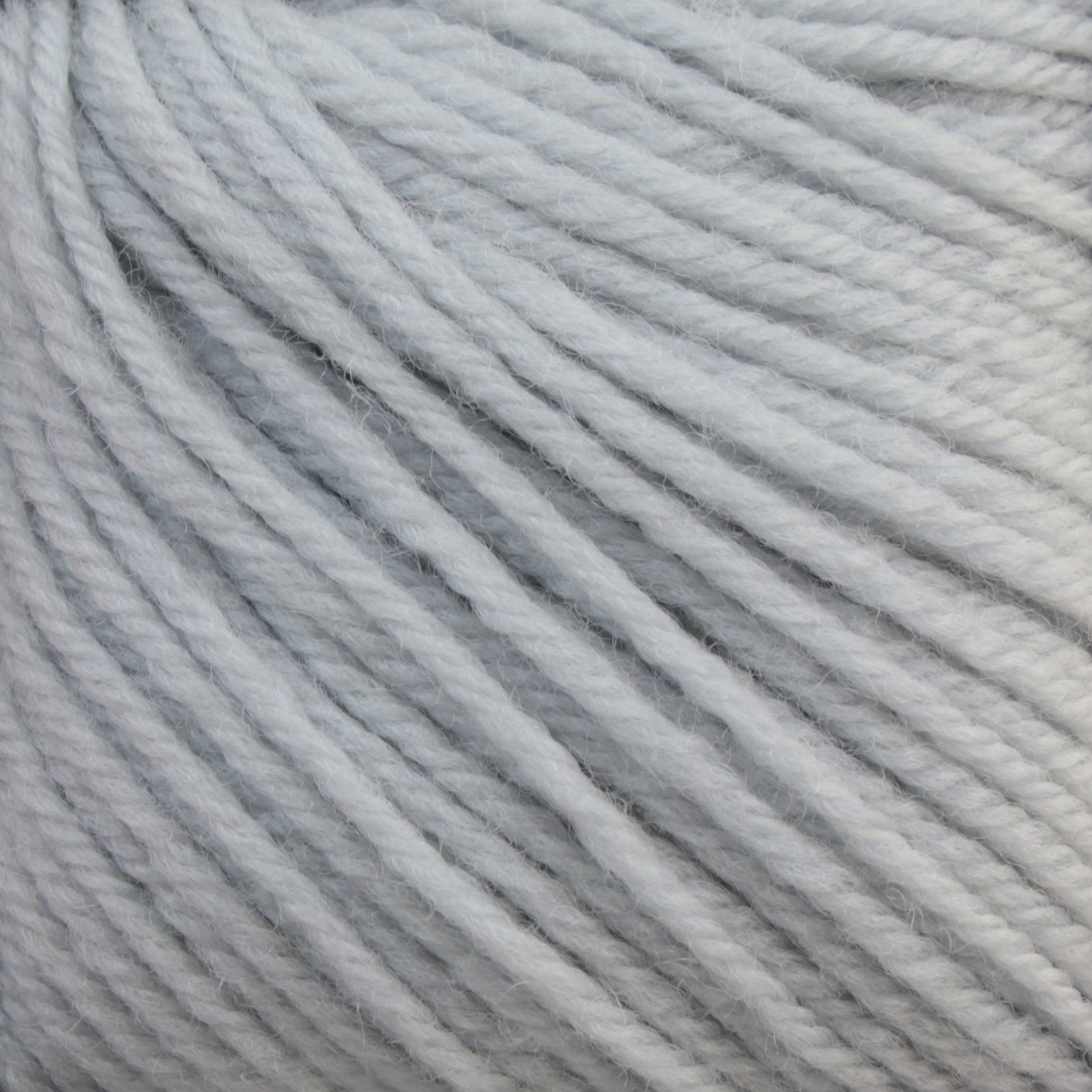 Close-up shot of light gray Baby Blatt yarn strands by Essentially Felt Studio & Fine Yarn, tightly wound together, showing a soft and fluffy texture. The fibers are neatly aligned, creating a smooth and uniform appearance suitable for knitting or crocheting projects. This fingering weight yarn is also machine washable for easy care.