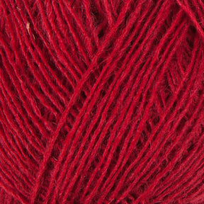 Close-up view of Berroco, Inc.'s Einband Lopi Icelandic wool fibers neatly wound into a ball. The texture of the yarn is visible, showing individual strands tightly wound together, creating a uniform surface perfect for lace knitting. The vibrant red color is consistent throughout the image.