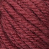 Close-up of thick, twisted yarn in a rich, reddish-brown color. The Halcyon Yarn Classic Rug Wool from Caledonian Dye Works features tightly woven strands, creating a textured surface. The image highlights the fibers and structure of the yarn, showcasing the artistry appreciated by rug weavers.