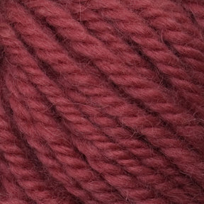 Close-up of thick, twisted yarn in a rich, reddish-brown color. The Halcyon Yarn Classic Rug Wool from Caledonian Dye Works features tightly woven strands, creating a textured surface. The image highlights the fibers and structure of the yarn, showcasing the artistry appreciated by rug weavers.