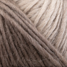 Close-up of two skeins of Louisa Harding Amitola Grande yarn by Knitting Fever / Euro Yarns in light brown and beige colors intertwined together. The texture of the yarns is soft and fluffy, with visible strands and fibers.