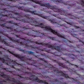 Close-up image of purple yarn intertwined with shades of lavender, blue, and pink fibers. The texture appears soft and slightly fuzzy, indicative of a warm, woolen material suitable for knitting or crocheting, showcasing the natural charm of unscoured Harrisville Designs' Harrisville Highland - Cones.