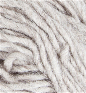 Close-up image of Jöklalopi (Bulky Lopi) by Berroco, Inc., showcasing off-white woolen yarn with thick, twisted fibers. The texture appears soft and slightly fluffy. The yarn is coiled loosely, with individual strands visibly intertwined, exuding a rustic handmade charm perfect for chunky winter sweaters.