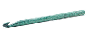 A handcrafted green Knitter's Pride Symfonie Dreamz wooden crochet hook from Accessories Unlimited is shown against a white background. The smooth finish of the hook, designed for catching yarn, features two decorative rings carved near the handle, exemplifying its exceptional quality.