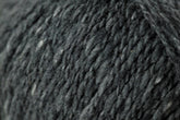 Close-up image of dark gray Jo Sharp Silkroad DK Tweed yarn from Kingfisher Yarn & Fibre, showcasing its soft and slightly fuzzy surface. The yarn appears dense and tightly spun, with subtle variations in shade that add depth to the monochromatic color.