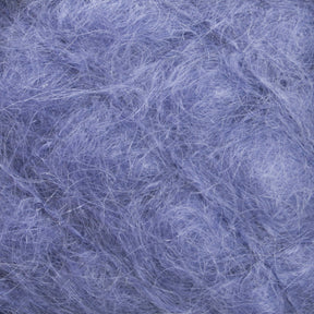 Close-up of a textured surface with a mixture of fine, thread-like fibers in various shades of blue, creating a soft, fluffy appearance. The fibers are loosely tangled, giving it a wispy and airy look, reminiscent of the luxurious Victorian Brushed Mohair Yarn from Caledonian Dye Works.