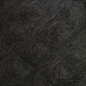 Here's a close-up view of the Victorian Brushed Mohair Yarn | Large Skein by Caledonian Dye Works. It features a dense, textured mass of dark and slightly wavy fibers. The colors range from dark gray to nearly black, with some lighter gray strands intermingled. This luxurious mohair appears tangled and intertwined, creating a chaotic, organic pattern reminiscent of Victorian yarns.