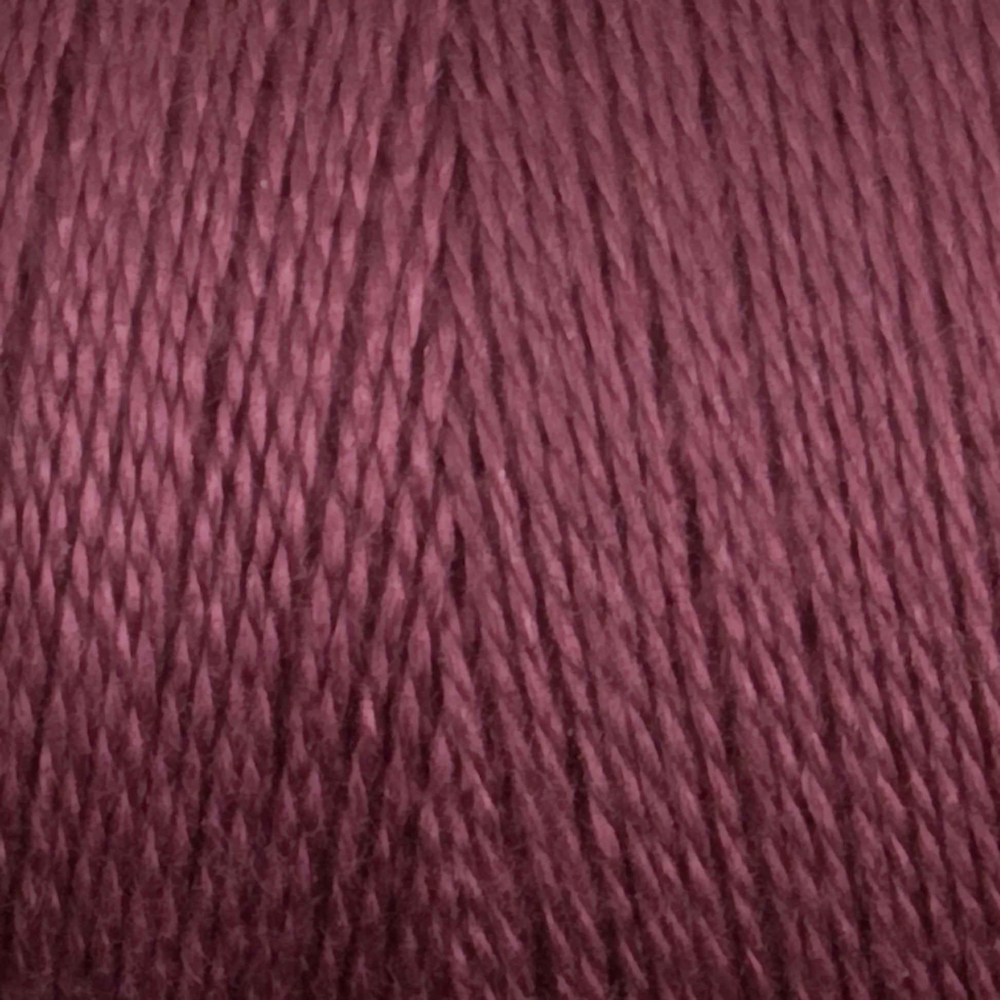 Close-up of a mini cone of Maurice Brassard 8/2 Tencel yarn in a rich mauve color, showcasing the twisted strands and texture. The yarn appears smooth and tightly wound, with a consistent and even color throughout. Perfect for knitting accessories, the image highlights the details of the fibers and their sheen.