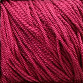 Close-up of strands of deep pink Cascade Ultra Pima Cotton Yarn by Cascade Yarns, featuring a tightly wound texture. Made from Peruvian Pima Cotton, the color is rich and consistent, showcasing the fibrous detail in the yarn's soft hand. This Ultra Pima yarn is perfect for knitting, crocheting, or other textile crafts.