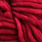 This close-up showcases the thick, chunky fibers of Malabrigo Rasta yarn. The twisted and woven fibers create a textured and cozy appearance, with a vibrant red color that remains consistent throughout. This super bulky yarn by Malabrigo Yarn has a rich, warm look—ideal for quick-to-knit projects.