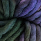 A close-up view showcases the thick, multicolored strands of Malabrigo Rasta yarn by Malabrigo Yarn, twisted together. This yarn features a gradient of colors that transition smoothly from deep green to various shades of purple, creating a soft and cozy texture perfect for quick-to-knit projects.