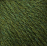 Close-up of green Peace Fleece Yarn by Harrisville Designs. The thick strands vary slightly in shade from light to dark green, creating a textured and slightly fuzzy appearance. This worsted weight yarn combines wool and mohair for a soft feel, making it perfect for knitting or crocheting projects.