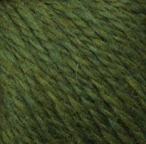 Close-up of green Peace Fleece Yarn by Harrisville Designs. The thick strands vary slightly in shade from light to dark green, creating a textured and slightly fuzzy appearance. This worsted weight yarn combines wool and mohair for a soft feel, making it perfect for knitting or crocheting projects.