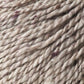 A close-up image of Jo Sharp Silkroad DK Tweed by Kingfisher Yarn & Fibre in beige, showcasing subtle hints of purple fibers intertwined. The texture appears soft and twisted, revealing the detailed fibers and strands. This thick, textured DK weight yarn seems perfect for knitting or crocheting luxurious projects.