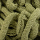 Close-up of a pile of Harrisville Potholder Loops - Traditional Size Mini Pack by Friendly Loom, tangled together. The texture of the cotton loops is clearly visible with a soft and slightly fuzzy appearance. The image highlights the intricate weaving pattern reminiscent of a traditional loom.