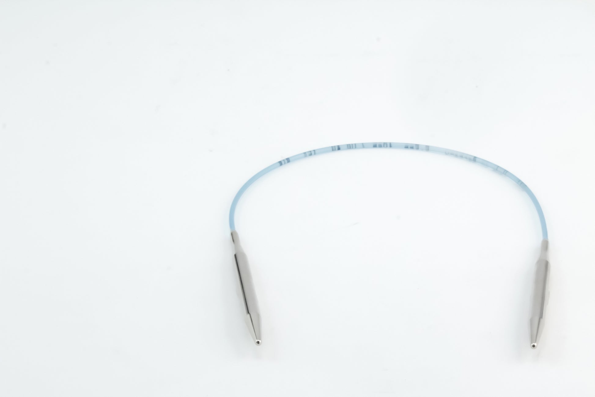 A pair of Addi Turbo Circular Knitting Needles by Skacel, featuring blue tubing and metallic ends designed with precision reminiscent of short circular needles, is shown against a white background.