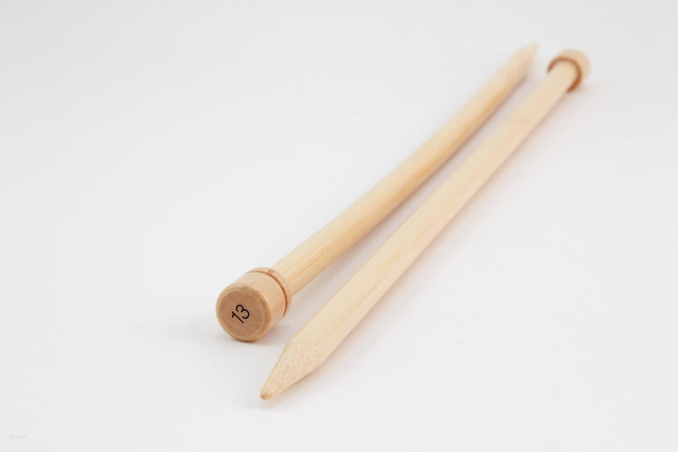 Two Bamboo Single-Point Knitting Needles from Accessories Unlimited are lying next to each other on a white surface. One needle has the number "13" printed on its rounded end. Both 12" knitting needles taper to a point at the other end.