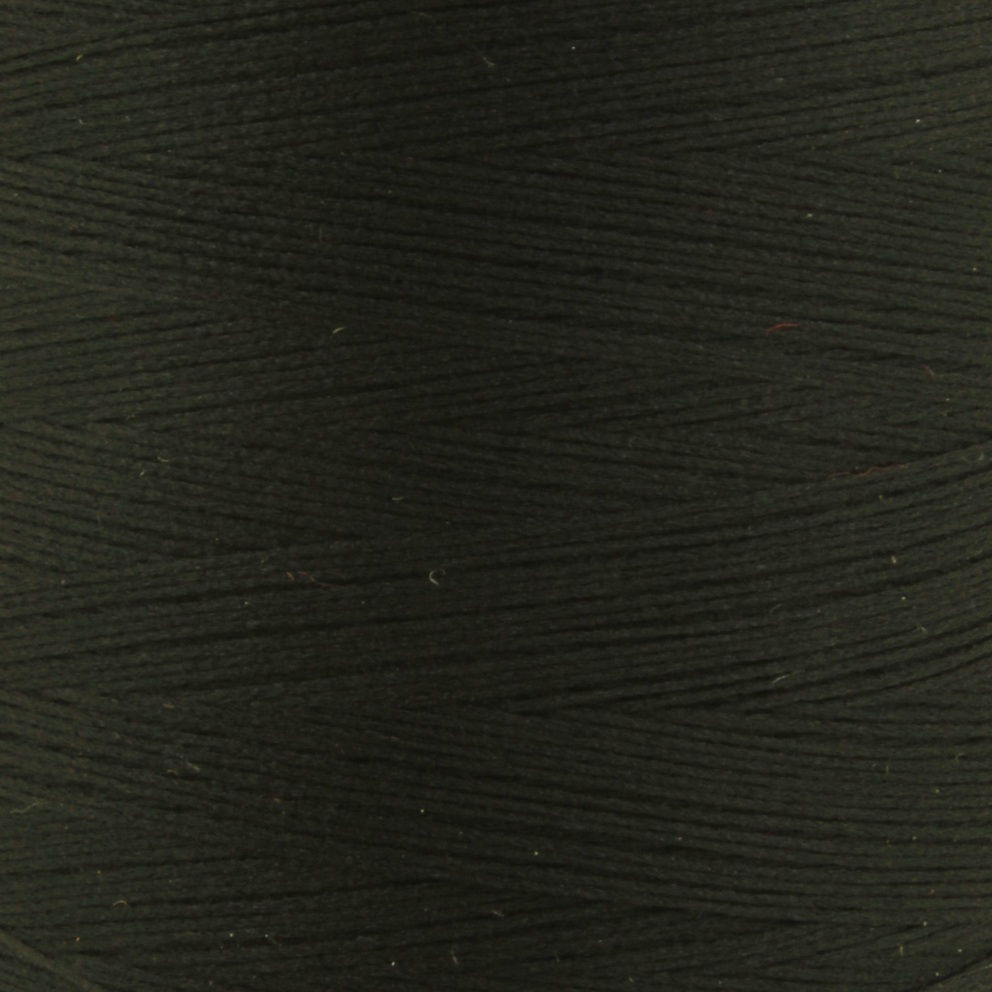 Close-up image of black Woolly Nylon Reinforcement Yarn by YLI Corp. wound tightly on a spool, displaying a uniform texture and pattern. The yarn appears smooth with subtle diagonal lines from the winding process, ensuring the security of your stitches.