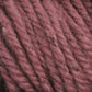 A close-up of Halcyon Yarn Classic Rug Wool skein in a soft, dusty pink reveals strands twisted together with a slightly fuzzy texture. The individual fibers are visible, showcasing the yarn's thickness and the rich hand-dye color by Caledonian Dye Works—a true gem for weavers.