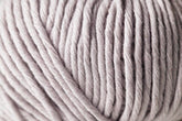 Close-up view of a ball of Jo Sharp Desert Garden Aran Cotton by Kingfisher Yarn & Fibre, showcasing its thick and smooth microfibre blend texture with tightly wound strands in a soft, light gray hue, perfect for optimal knitting performance.