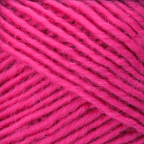 A close-up view of the vibrant, pink Lamb's Pride Worsted Yarn by Brown Sheep. The yarn strands are neatly coiled, showcasing a smooth, fibrous texture that creates a visually appealing pattern. Its bright and vivid color suggests it's perfect for lively and bold knitting or felting projects.