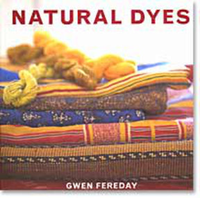 The book cover for "Natural Dyes" by the British Museum Press displays the title in bold red letters at the top. It beautifully showcases skeins of vividly dyed yarns resting on colorful, patterned fabrics that highlight a variety of dyeing techniques. The author's name, Gwen Fereday, is elegantly written in white letters at the bottom of the cover.