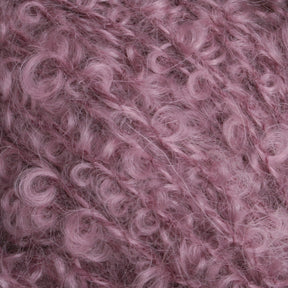 Close-up of a textured, fluffy pink yarn with curly fibers. The Victorian Bouclé Mohair Yarn, part of Caledonian Dye Works' Signature Victorian Collection, has a soft appearance, with tightly coiled loops giving it a fuzzy and voluminous look.