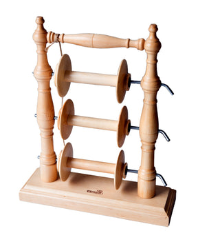 The Kromski Lazy Kate Arch, by Kromski North America, is a wooden spool holder featuring three horizontal rods designed to hold spools of thread, reminiscent of the classic Kromski Lazy Kate. Its frame comprises two intricately turned vertical posts, a base, and a hanging rod. Each rod is equipped with metal hooks at the ends to secure the spools and provide tension control.