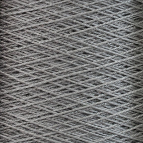 Close-up of tightly wound gray 10/2 Pearl Cotton Yarn from Supreme Corp. with a slightly fuzzy texture. This versatile yarn is woven in a crisscross pattern, forming a dense and intricate network of fibers known for its exceptional colorfastness.