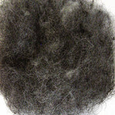 A close-up photo of Harrisville Dyed & Carded Wool Fiber by Harrisville Designs, showcasing heathered colors with a mass of tangled, curly strands intertwined with lighter grey fibers. The texture appears coarse and dense, reminiscent of felting wool. The background of the image is not visible.