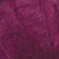 Close-up image of a ball of textured, fuzzy magenta-colored Victorian Brushed Mohair Yarn from Caledonian Dye Works. The fibers are loosely spun and have a soft, hairy appearance, reminiscent of luxurious mohair, giving the yarn a light and airy look.