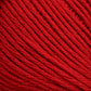 Close-up image of Brown Sheep's Cotton Fleece yarn in multiple strands wound together, showing texture and fibers in detail. The yarn appears to be tightly wound, with individual threads visible, creating a dense, vibrant red fabric perfect for intricate knitting patterns.