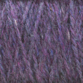 Close-up of a section of Harrisville Highland - Cones yarn by Harrisville Designs, showcasing a blend of purple, blue, and pink fibers interwoven. The texture is soft and fuzzy, with distinct strands visible, contributing to a vibrant, multi-tonal look.