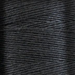 A close-up view of tightly wound black thread or yarn from the 16/5 Linen Rug Lacing (Black) | Mini-cone by Stuart C. Hurlbert & Co., showcasing the texture and detail of each strand. The smoothness is evident, with fibers appearing neatly aligned, hinting at the strength that makes them ideal for the heaviest rugs.