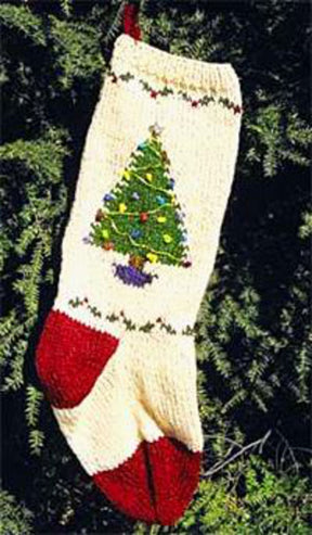 A decorative stocking from the Bully Woolies "Maine Christmas Stocking Kit" is meticulously crafted from Maine spun wool and is hanging outdoors. This stocking features a detailed pattern with a red heel, toe, and hanger. An embroidered Christmas tree adorned with ornaments takes center stage, surrounded by festive green and red stitching patterns.