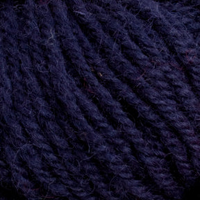 Close-up image of Caledonian Dye Works Halcyon Deco Rug Wool in a rich, dark purple hue, showcasing the tightly twisted fibers with subtle color variations and a hint of fuzziness. The 100% wool yarn has a soft and thick texture, making it perfect for knitting or crocheting projects.