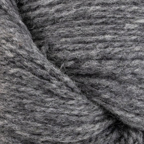 Close-up of a skein of gray yarn with thick, soft fibers. The yarn, named Patagonia Organic Merino by Juniper Moon Farm from Knitting Fever / Euro Yarns and made from GOTS certified Organic Merino Wool, features slightly varying shades of gray that give it a natural and slightly heathered appearance.