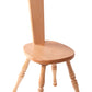 The Ashford Spinning Chair by Ashford Handicrafts Limited is a light, wooden chair crafted from New Zealand Beech. It features a high, rectangular backrest with a handle cutout at the top. The chair boasts a smooth and comfortable seat, supported by four intricately turned legs that lend it a classic, rustic appearance. The background is white.