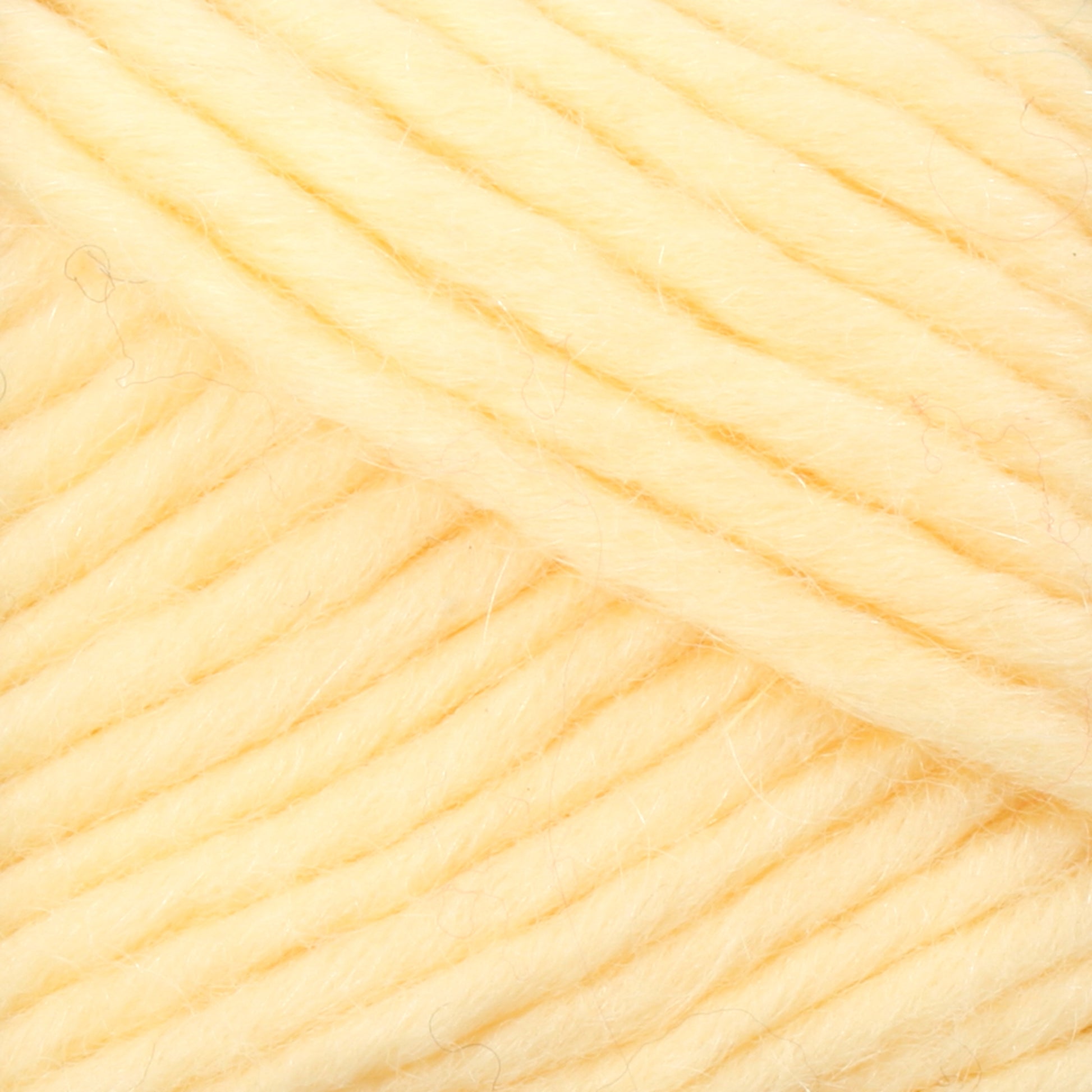 Close-up of Brown Sheep's Lamb's Pride Bulky Yarn, a thick and soft yellow yarn. The yarn is densely packed, showcasing its texture and fibers. Often used by knitters and crocheters, the strands are neatly wound and parallel to each other, highlighting the uniformity and plush quality of the material.